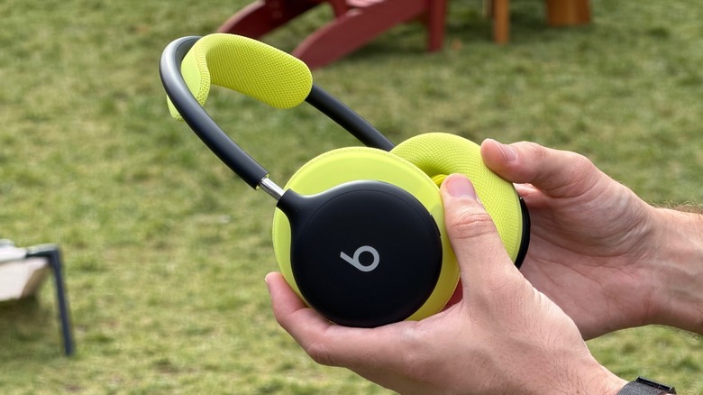 Man holding Beats 360 headphones in a park
