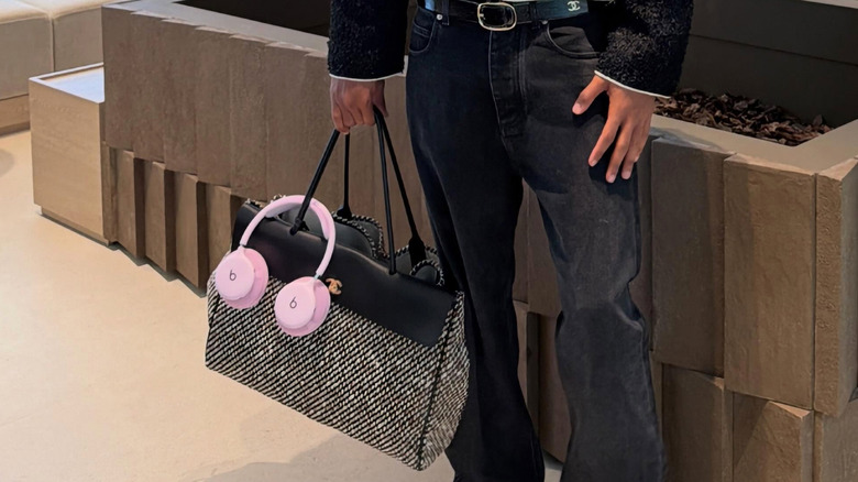 A man holding a luxurious bag and Beats unreleased headphones
