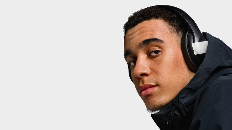 Man wearing Beats headphones with a tape on the logo
