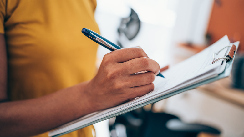 A woman holding a clipboard during a selection process