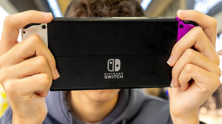 Someone holding a Nintendo Switch 2 with one hand