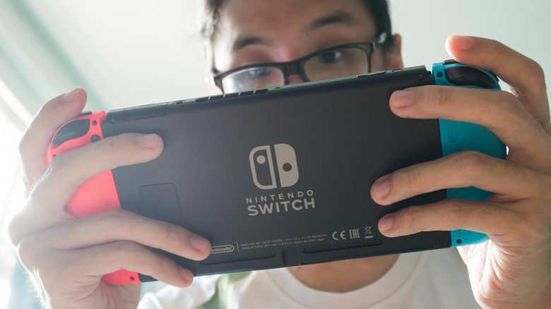 A man playing a Nintendo Switch