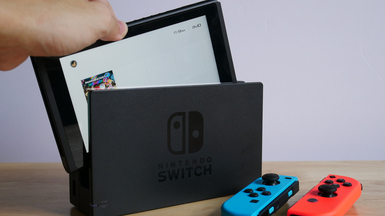 A Nintendo Switch being inserted into a dock