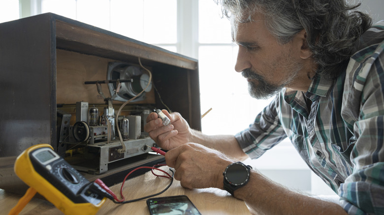 A man repairing a vintage radio receiver