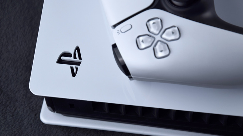 DualSense controller resting atop a Sony PlayStation 5 console.