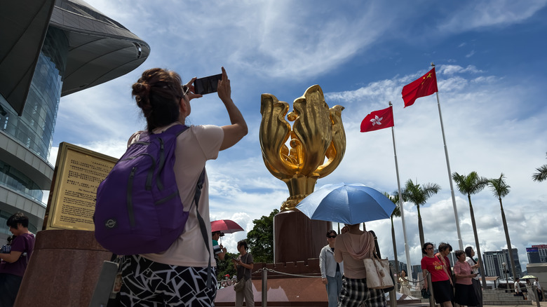 A tourist takes a smartphone photo in Hong Kong.