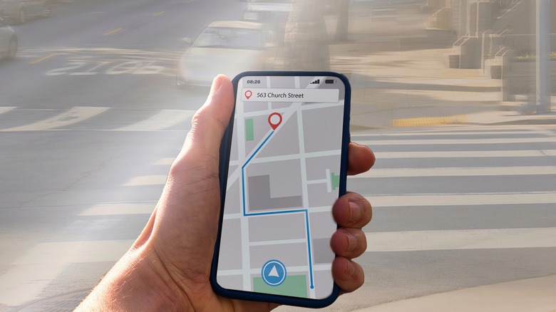 A person getting directions from a map app on a smartphone while on the street.