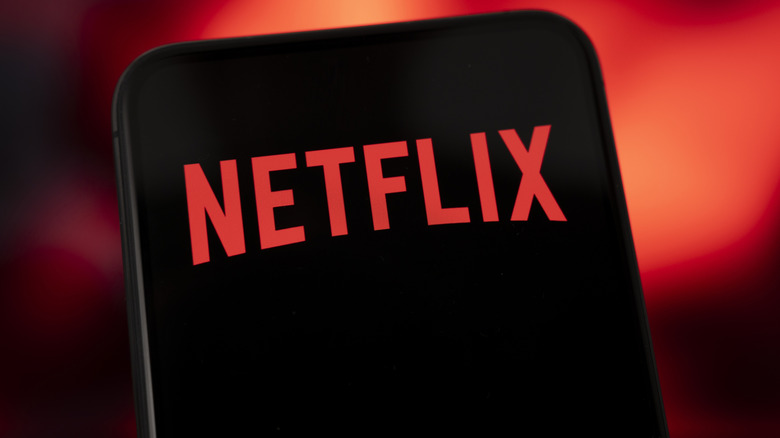 Netflix logo displayed on a smartphone screen, against a red background