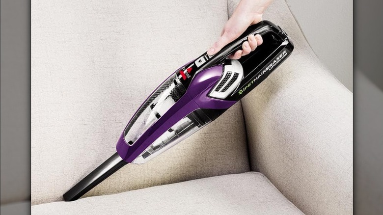 Cleaning between the sofa using hand vacuum