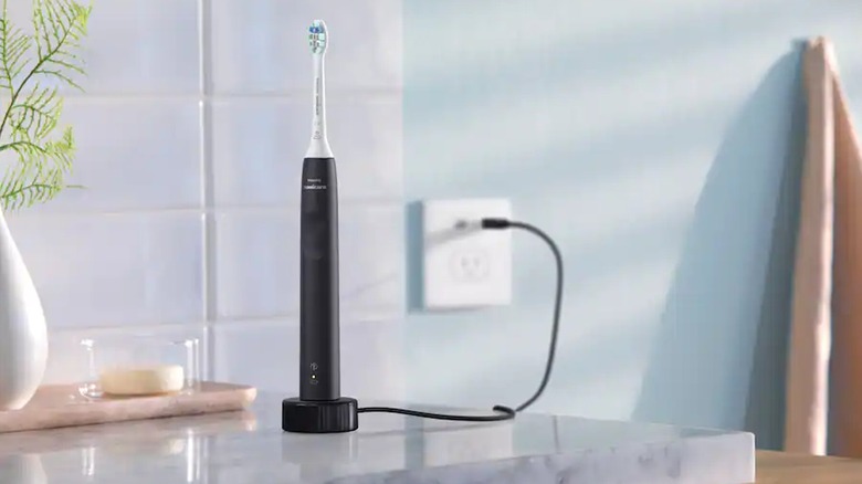 Power toothbrush with a cord plugged into the electrical socket