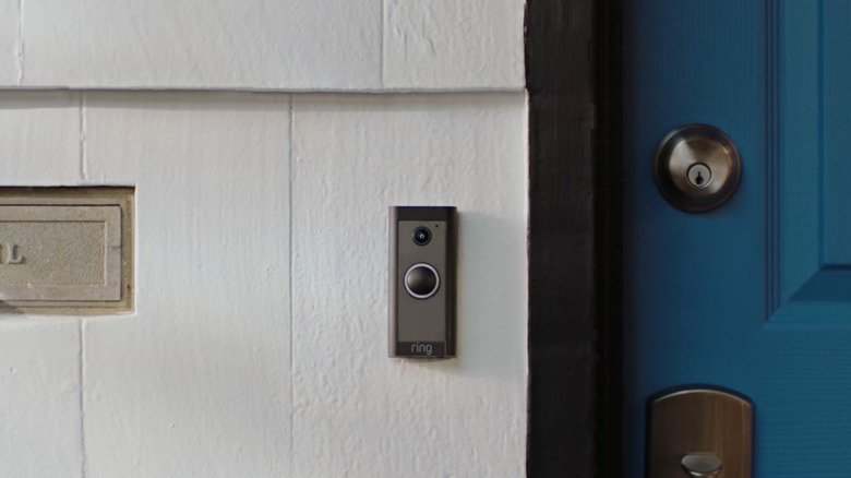 Smart video doorbell installed beside a blue door
