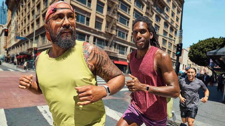 A group of men wearing the Fitbit Charge 6 while running on the street.