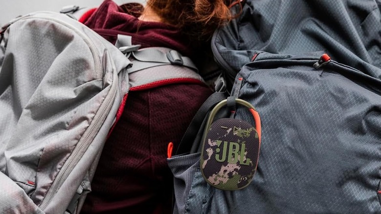 The JBL Clip 5 strapped to a backpack.