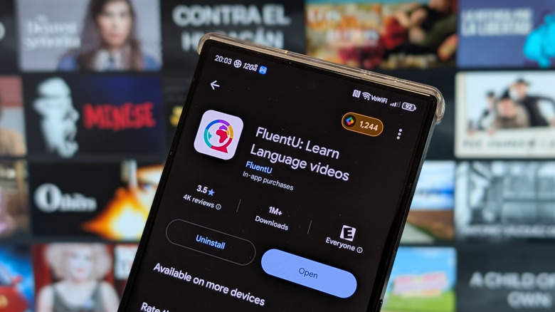 FluentU language learning app on smartphone in front of Netflix on television