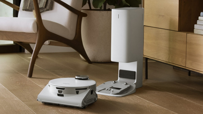 The Samsung Jet Bot AI+ vacuum cleaner and its dock in a living room.