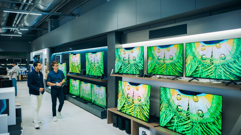Customers walking in the TV section of a store