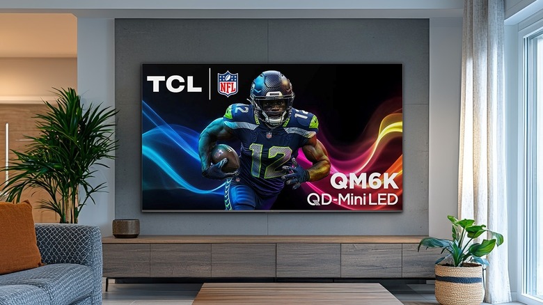 The TCL QM6K TV mopunted on a wall in a living room