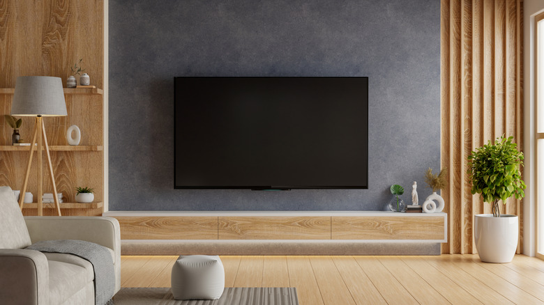 LG TV against the back of a wall with a car driving down a ruined city