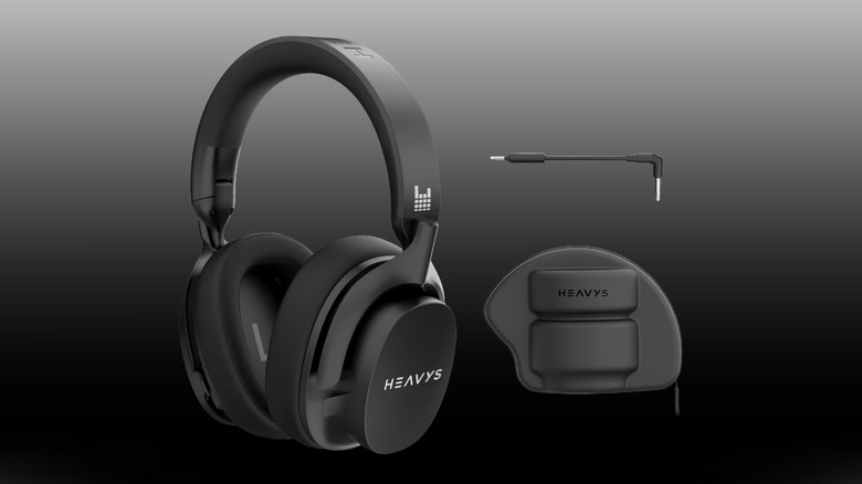 A pair of black Heavys H1H headphones beside a case and cable on a black-to-white gradient background.