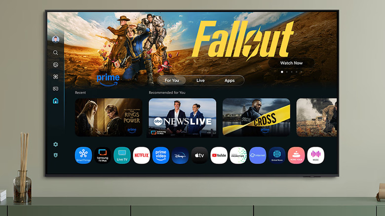 A wall-mounted Samsung Q7F TV showing the home screen