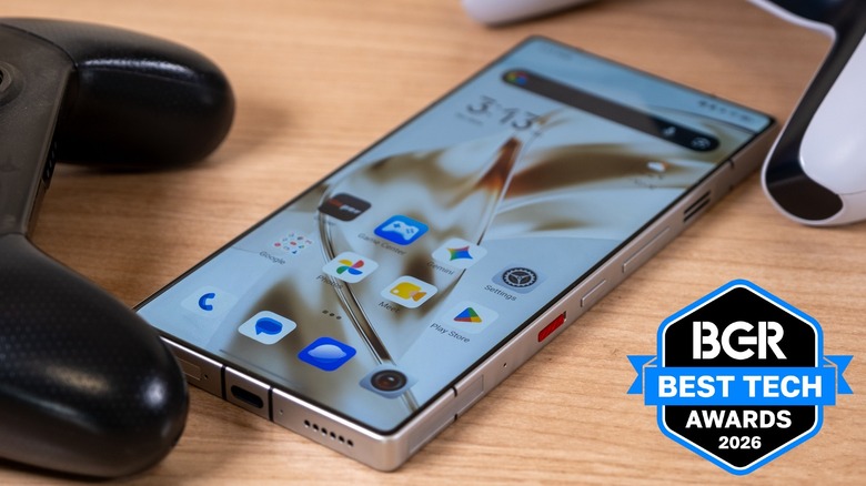 The RedMagic 11S Pro phone sitting on a desk between two game controllers.