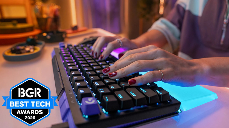 Person typing on the Logitech G512 X 75% keyboard with blue RGB on a desk