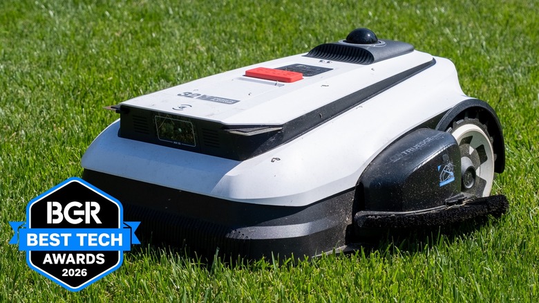 Ecovacs robot mower on a bright green grass lawn.