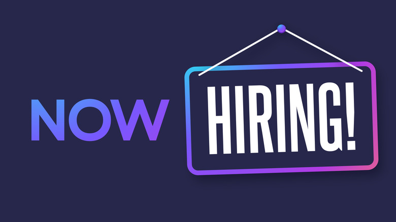 Now Hiring sign on a purple background.