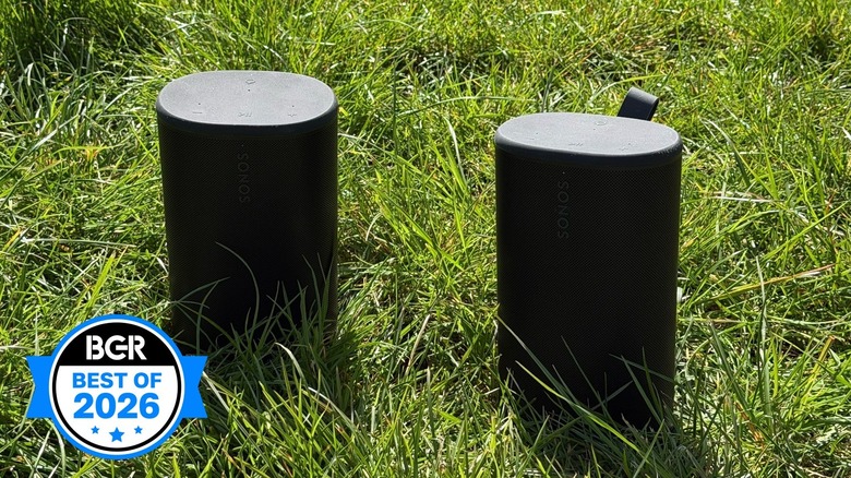 Sonos Play speakers sitting on a grassy field.