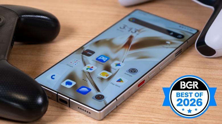 The RedMagic 11S Pro phone sitting on a desk between two game controllers.