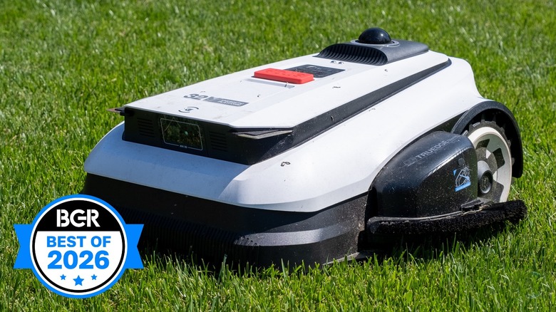 Ecovacs robot mower on a bright green grass lawn.