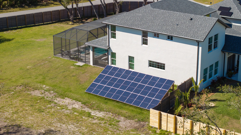 A house with ground-mounted solar panels
