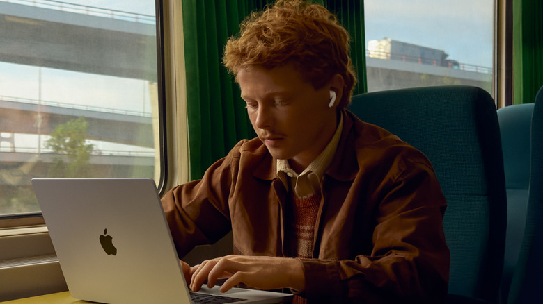 Person on train listening to AirPod Pro 3