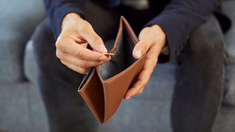 Person opening an empty wallet