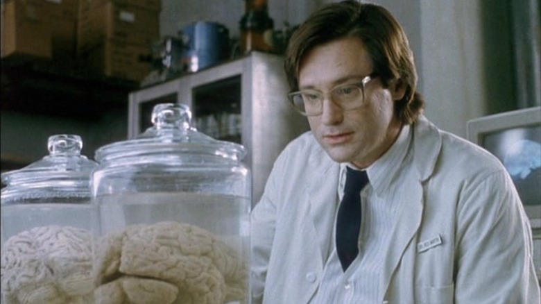 Dr. Martin looking at a brain in a jar in "Brain Dead."