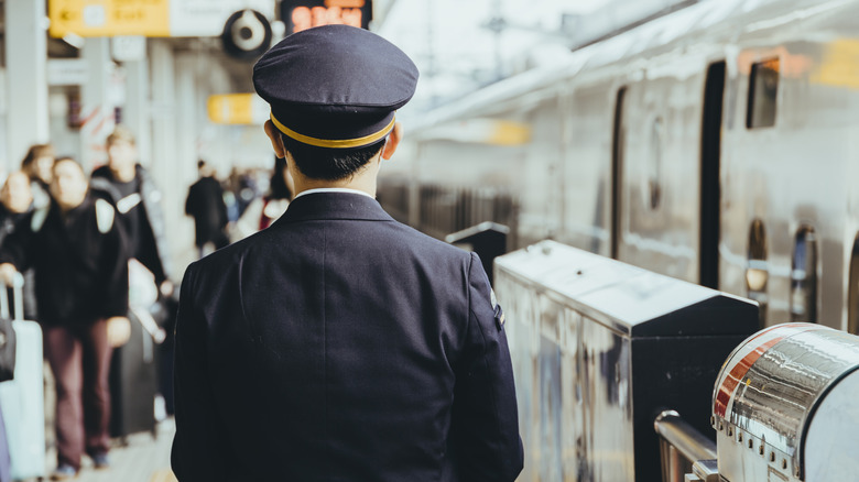 View from behind a Japanese railway officer observing the station for safety.