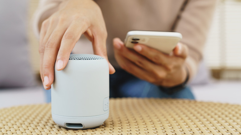 Close up of someone pairing their smartphone with a Bluetooth speaker.