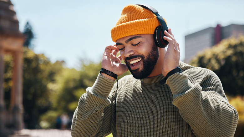 Someone listening to wireless headphones audio outdoors.