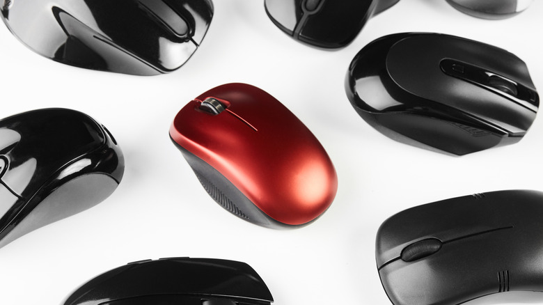 a bunch of wireless computer mouses, all black with one red