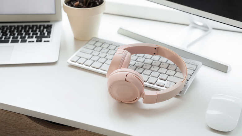 Bluetooth devices stacked on a desktop, including a mouse, keyboard, and headphones.