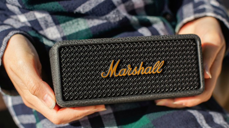 A Marshall Bluetooth speaker held in someone's hands