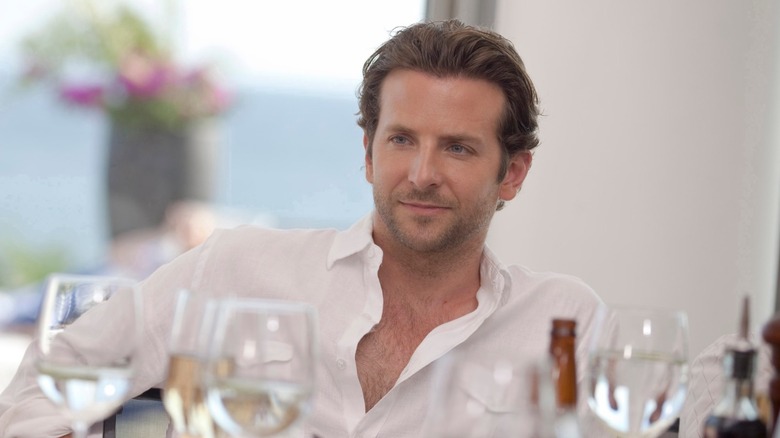 Bradley Cooper as Eddie Morra sitting at a table in Limitless