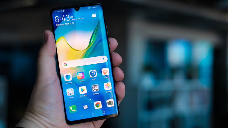 Person holding up a Huawei Android smartphone with the screen on.