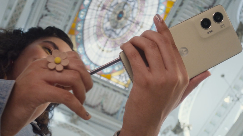 A woman retrieving the stylus from the Motorola Moto G Stylus phone