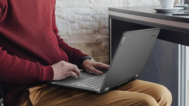 A dark gray Lenovo Ideapad Flex 5i Chromebook Plus on a person's lap.