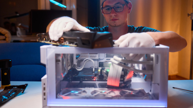Someone installing a modern graphics card in a custom PC case.