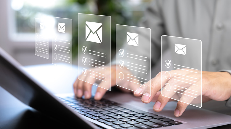 Two hands on the keyboard of a laptop as superimposed graphics of several email columns with check-marked lists appear over the user's hands