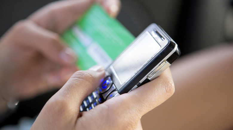 Someone activating a prepaid phone with a payment card in the background.