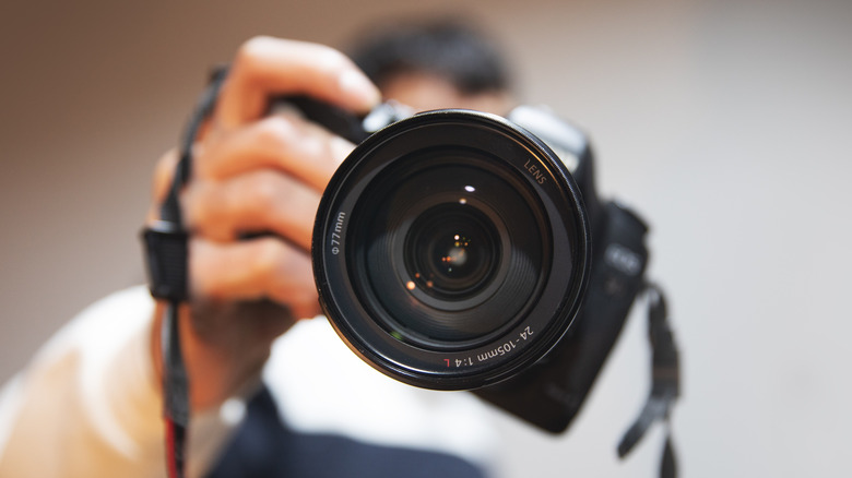 Person taking a photo with a camera in close-up.