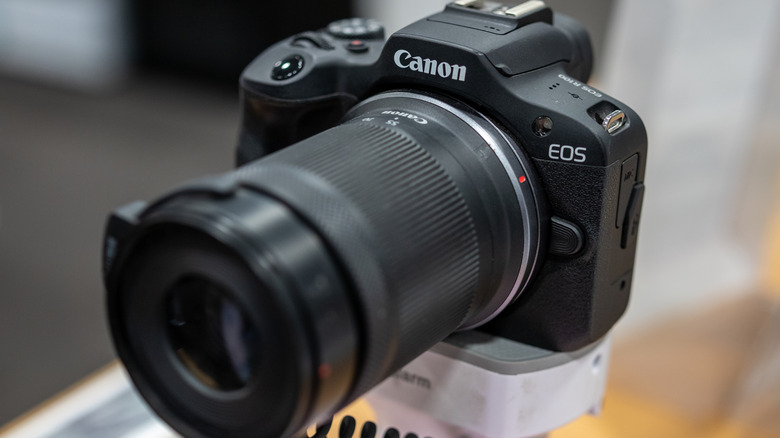 Canon EOS mirrorless camera with a zoom lens shown in close-up.